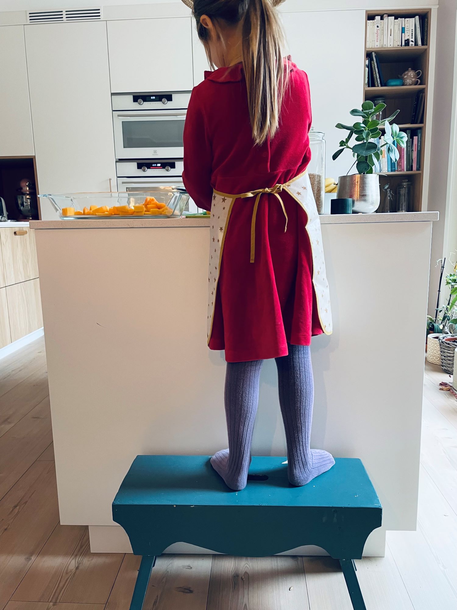 M bruker en krakk for å nå opp til benkeplaten.