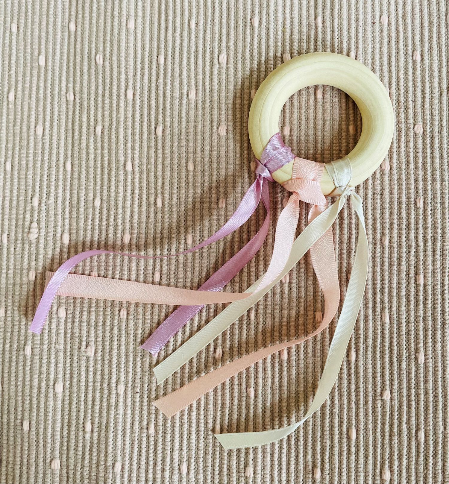 Denne leken kan du lett lage selv ved å feste noen fine silkebånd på ringen. Det blir vakkert med grunnfargene rød, blå og gul. Pass på at båndene ikke bli for lange slik at babyen ikke kan få dem rundt halsen.