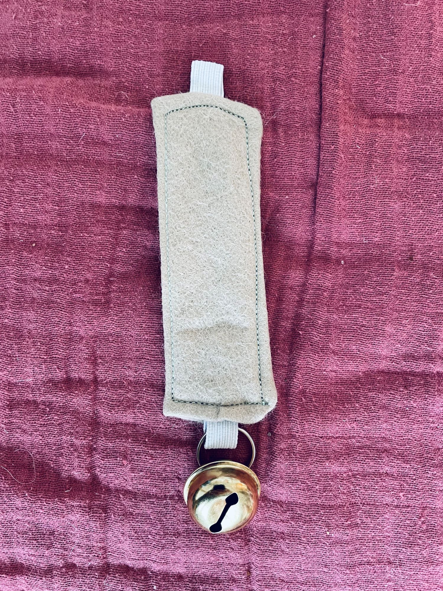 Også denne leken her kan du raskt lage selv. Alt du trenger er en bjelle, en liten nøkkelring, et elastisk bånd og litt stoff - jeg har valgt filt siden det er fint å ta på for babyen.